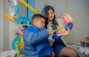 Madre ayudando a su hijo a cepillarse los dientes para prevenir las caries infantiles.